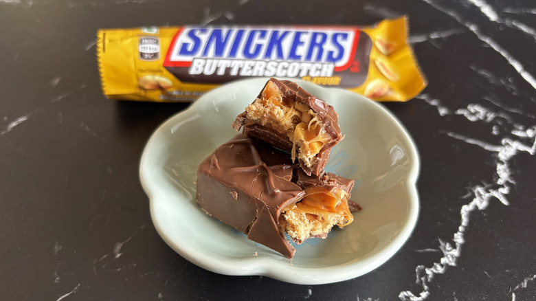 Snickers candy bar with wrapper in background