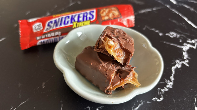 Snickers candy bar with wrapper in background