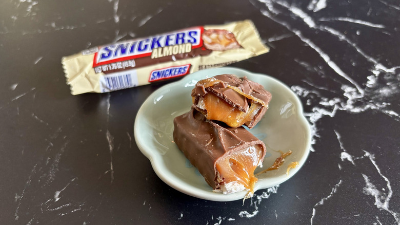 Snickers almond candy bar with wrapper in background