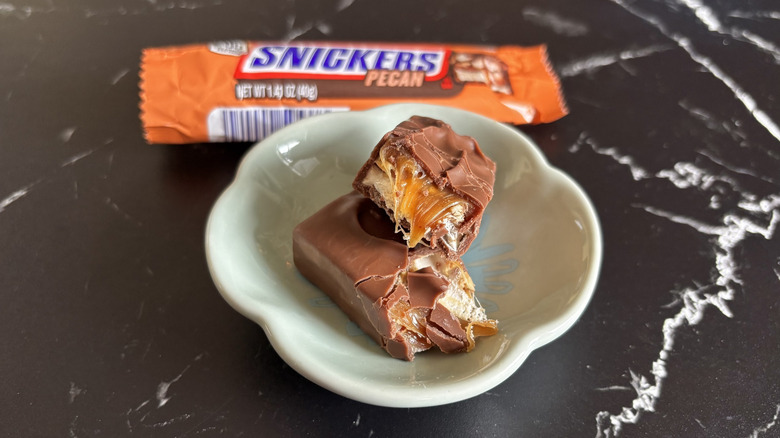 Snickers pecan candy bar with wrapper in background