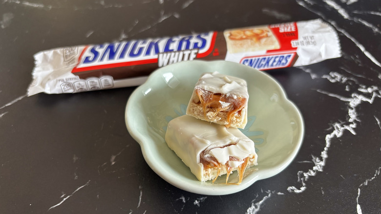 Snickers white chocolate candy bar with wrapper in background