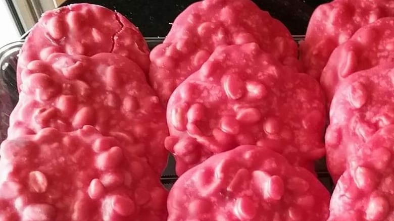 A tray of bright red, peanut patty rounds