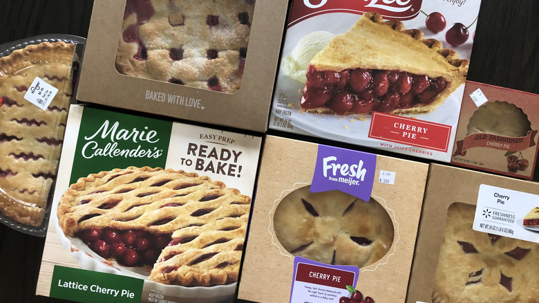 7 different store bought cherry pies in boxes.