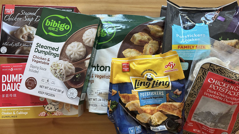 Variety of store-bought frozen chicken dumpling packages on wooden table