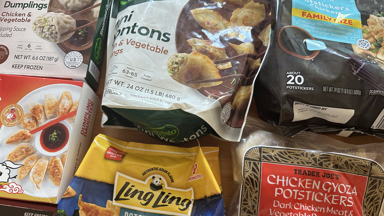 Variety of frozen chicken dumpling packages on wooden table
