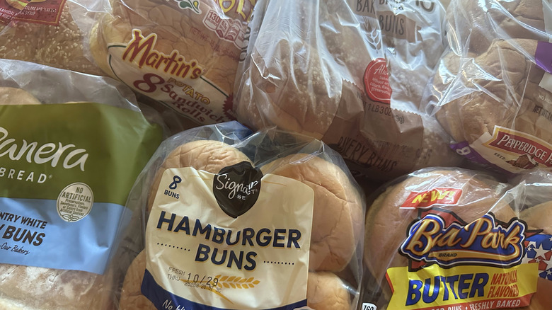 Variety of burger bun packages on wooden table