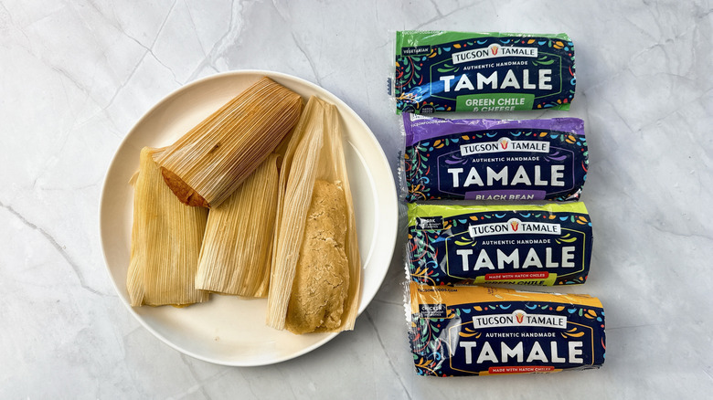 tamales on a plate with 4 packets of tamales alongside