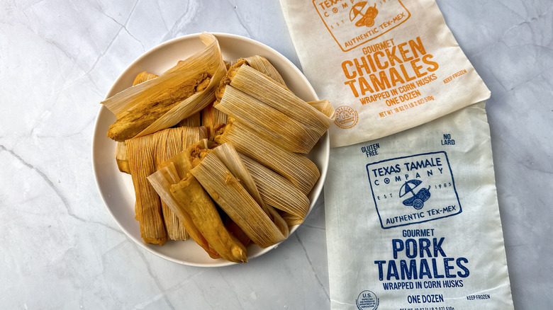 tamales on a plate with cloth packaging alongside