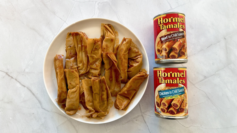 tamales on a plate and 2 cans of tamales