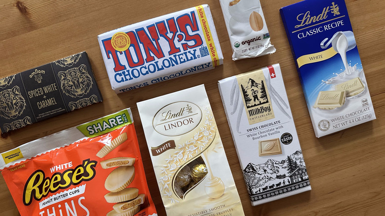 White chocolate bars and candy on wooden table
