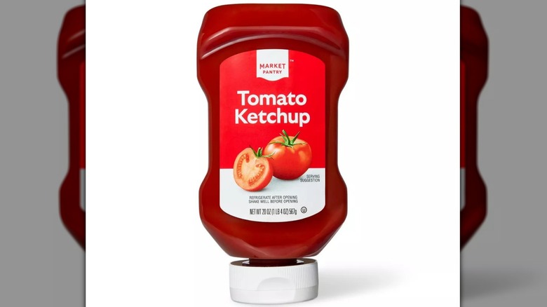 A bottle of Market Pantry Tomato Ketchup sitting upside down.