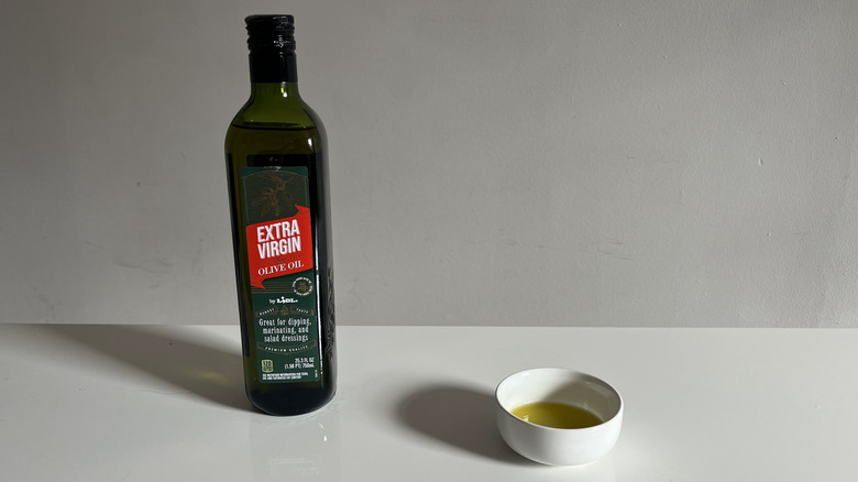 Lidl olive oil with a bit poured into a little white dish beside it