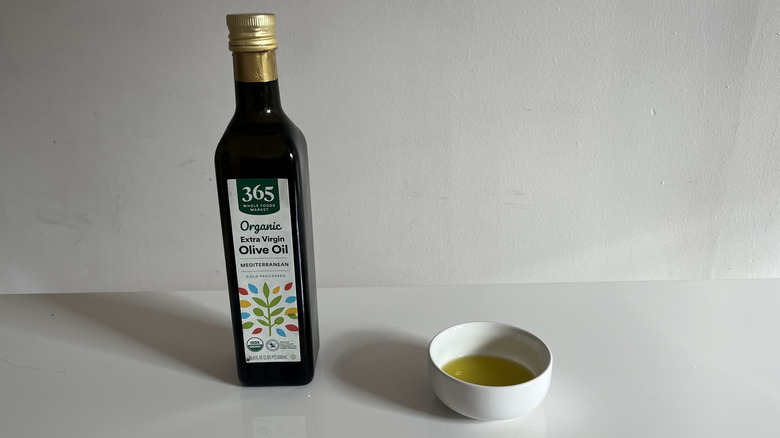 365 olive oil with a bit poured into a little white dish beside it