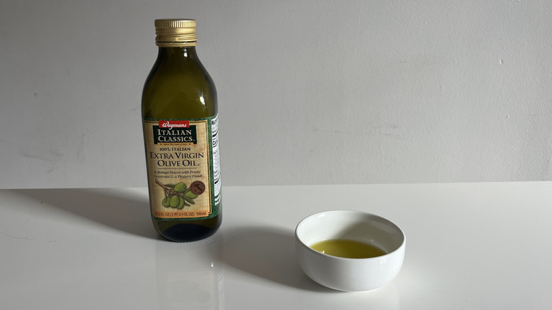 Wegmans olive oil with a bit poured into a little white dish beside it