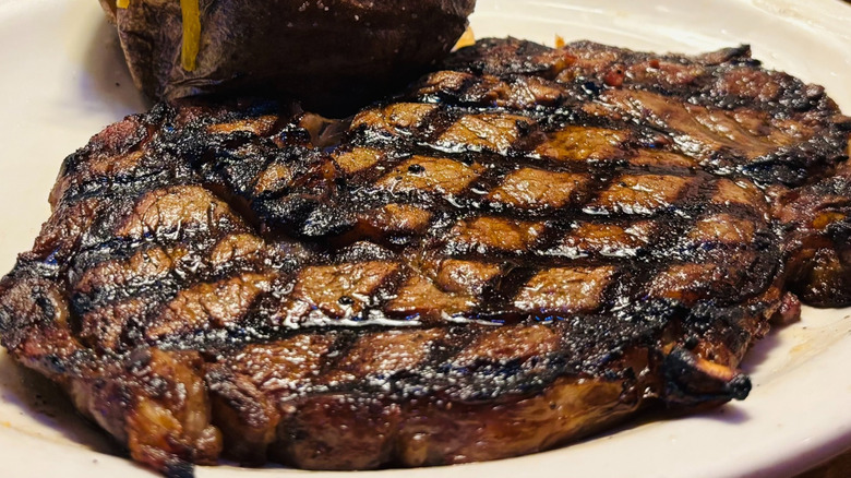 A steak and baked potato from Texas Roadhouse on a plate