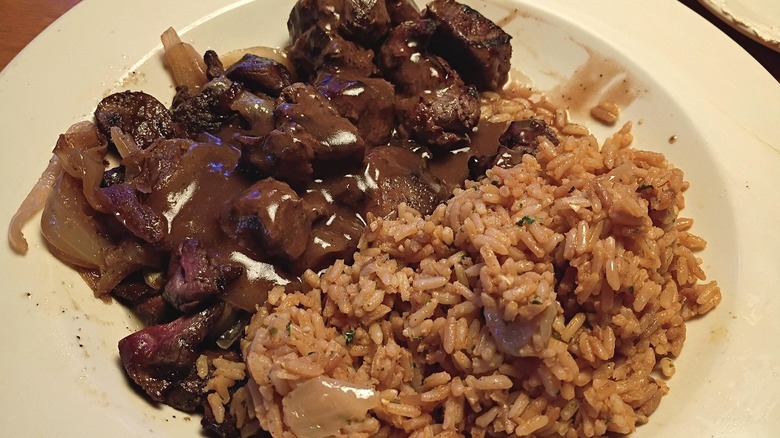 Texas Roadhouse beef tips with rice on white plate