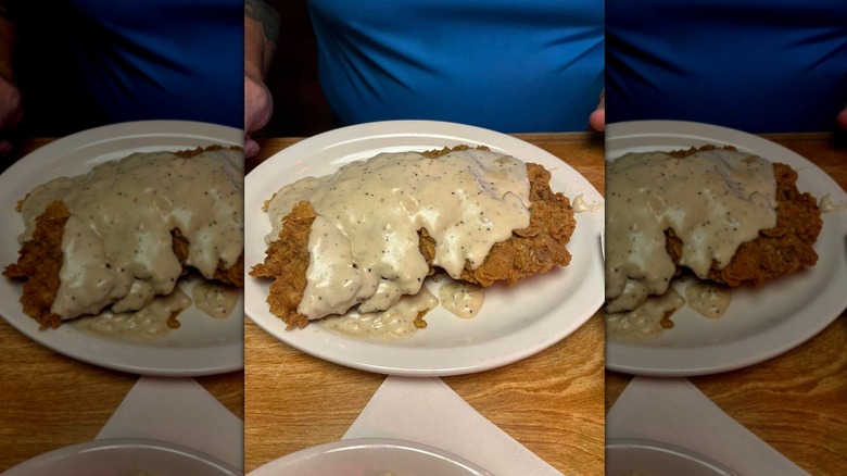 Texas Roadhouse country fried sirloin with gravy on white plate