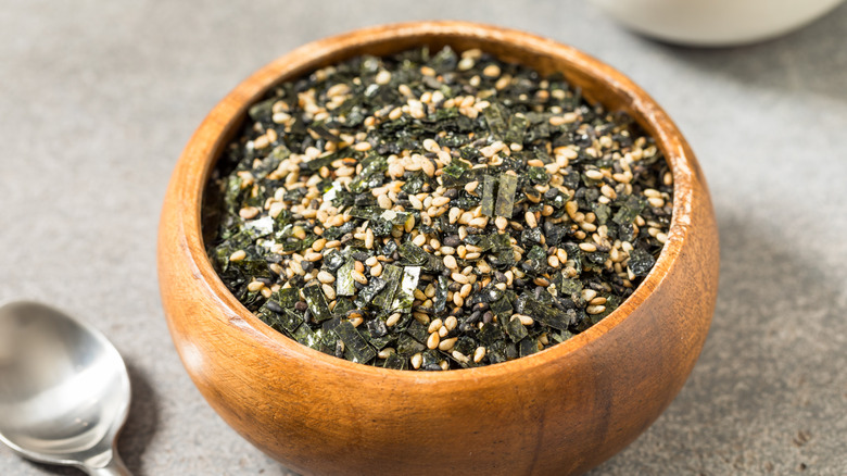 Furikake seasoning in a wooden bowl on a table.