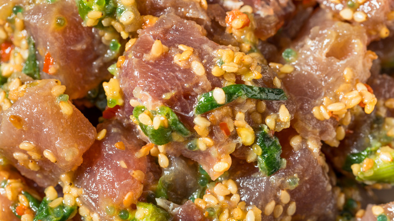 Marinated cubed ahi tuna for poke with sesame seeds and other ingredients.