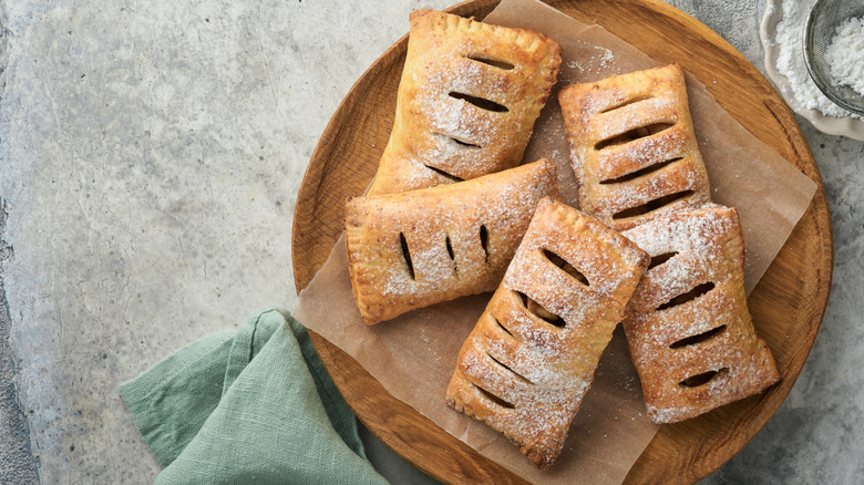Top-down shot of five hand pies on wooden round tray