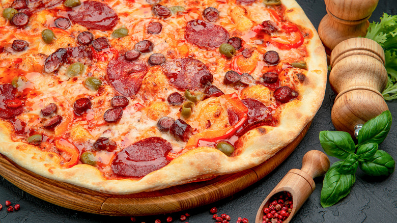 Pizza topped with salami, sausage, and olives