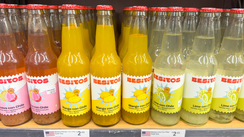 Several Besitos soda bottles lined up on store shelf