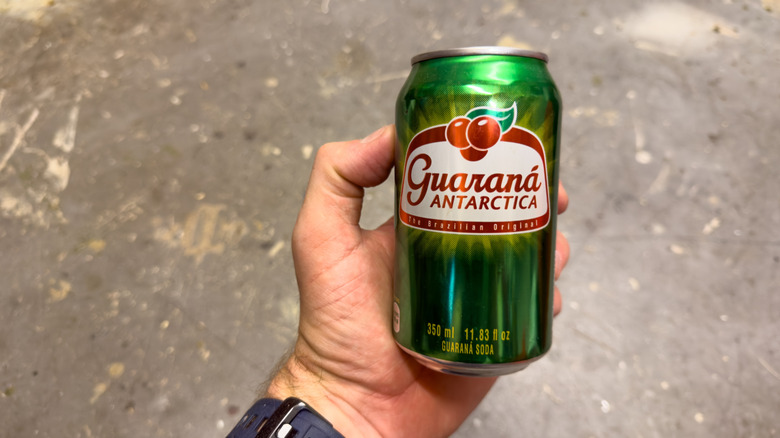 Hand holding can of Guaraná Antarctica