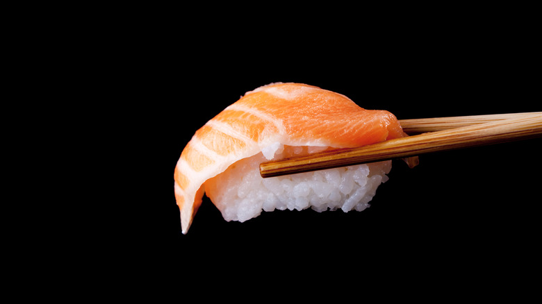Close-up of chopsticks holding piece of sushi