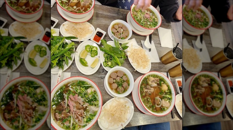 Table spread of Vietnamese dishes and garnishes