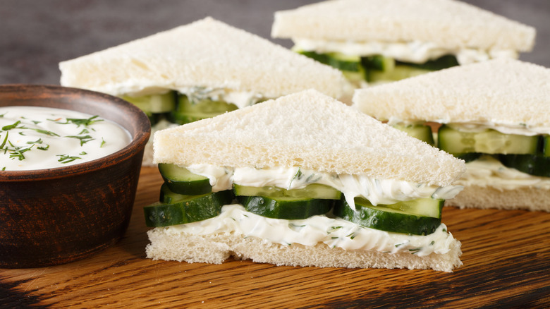 Cucumber cream cheese sandwiches closeup on the wooden board on the table