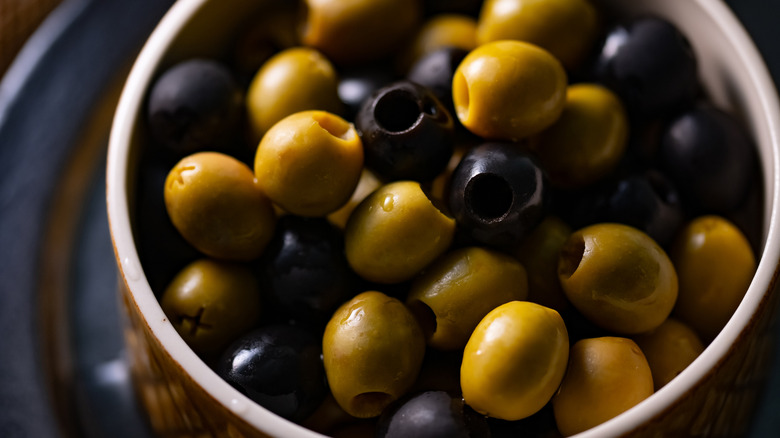 Close-up of green and black olives in a dish