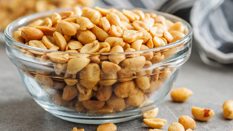 Salted roasted peanuts in a glass bowl on a table