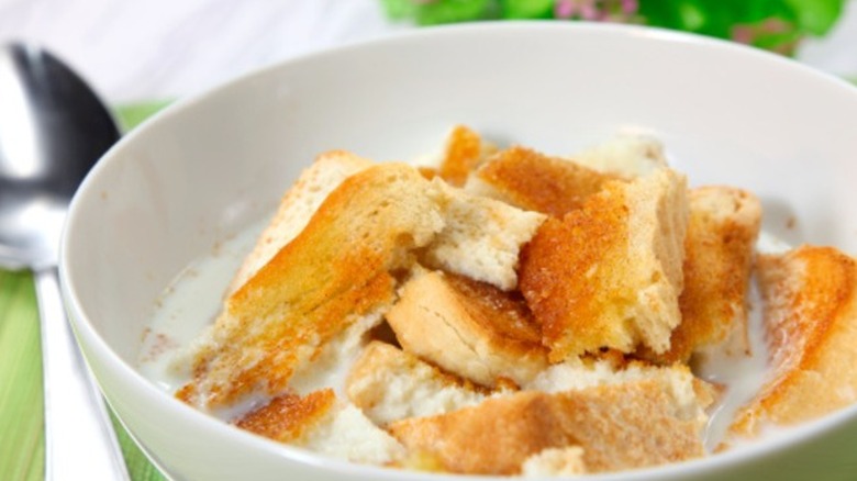 Milk toast in a bowl next to spoon mirrored image black border