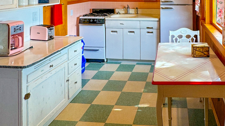 retro kitchen with checkered linoleum floors and white and wooden cabinets