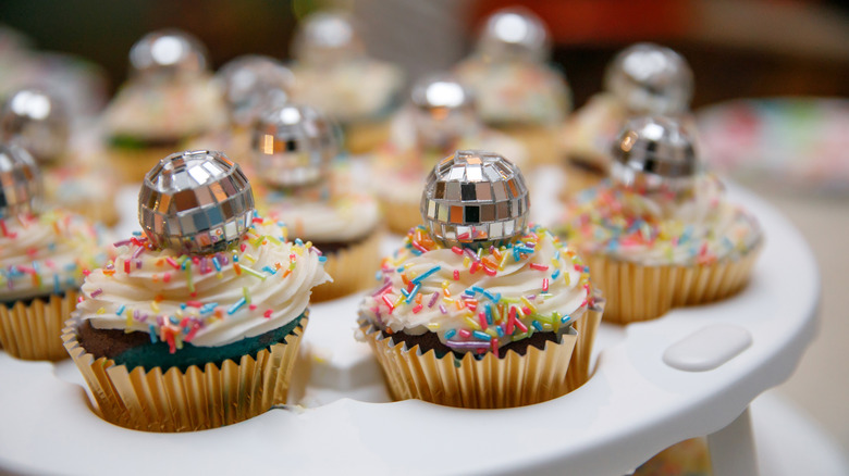 Cupcakes topped with disco balls in carrier