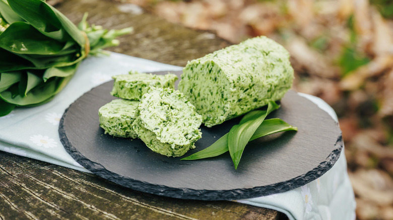 Homemade herb butter on cutting board outside