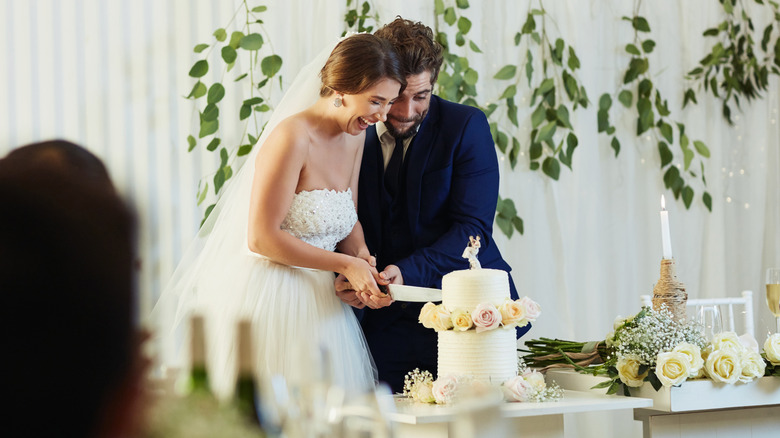 bride and groom slicing wedding cake