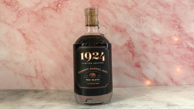 Bottle of 1924 Whiskey Barrel Aged red wine on pink background