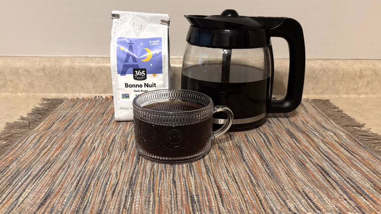 365 Whole Foods Bonne Nuit coffee in bag, brewed in pot, and in glass mug on neutral countertop