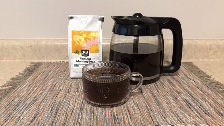 365 Whole Foods Pleasant Morning Buzz coffee in bag, brewed in pot, and in glass mug on neutral countertop
