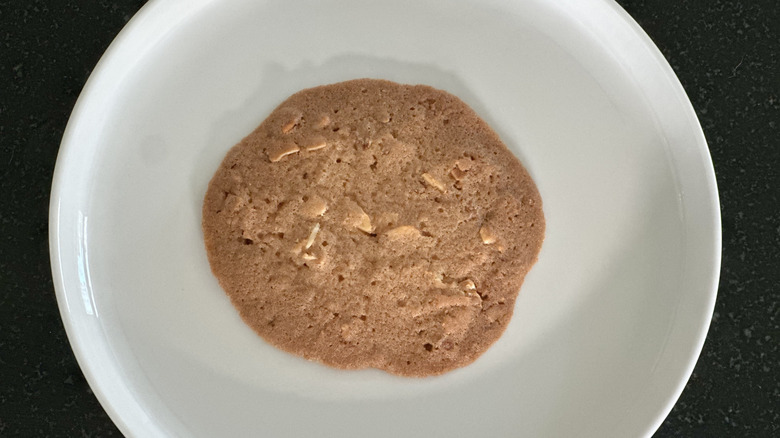 Overhead image of white plate with crispy almond cookie