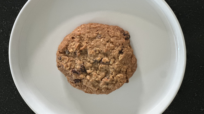 Overhead image of white plate with oatmeal raisin cookie