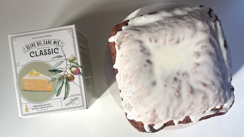 Box of Williams Sonoma Classic Olive Oil cake mix next to classic olive oil cake on white table