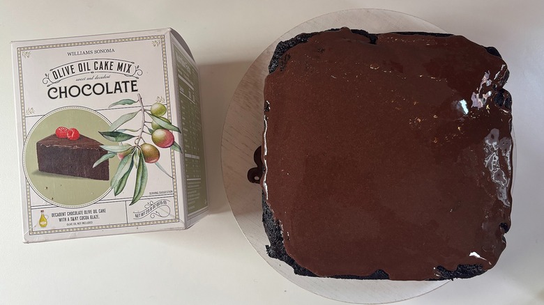 Box of Williams Sonoma Chocolate Olive Oil cake mix next to chocolate olive oil cake on white table
