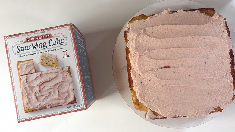 Box of Williams Sonoma Strawberry snacking cake mix next to strawberry cake on white table