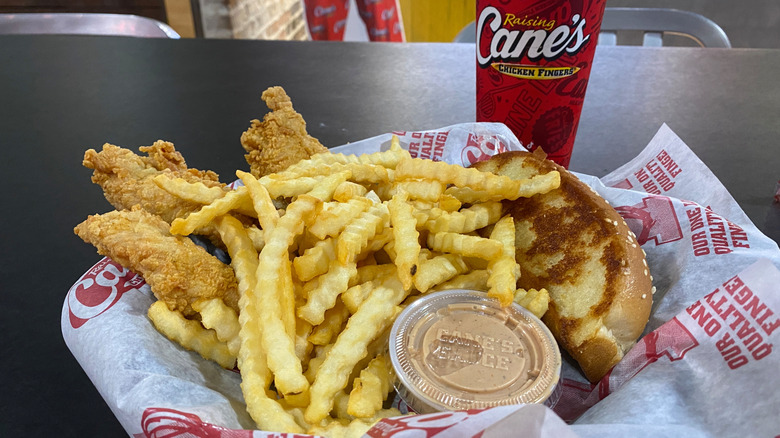 Plate of chicken tenders and fries with soft drink from Raising Cane's