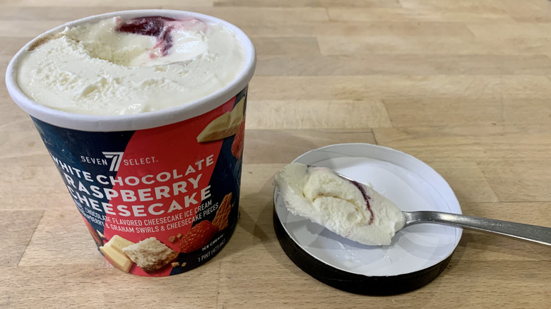 opened White Chocolate Raspberry Cheesecake pint with spoonful of ice cream next to it