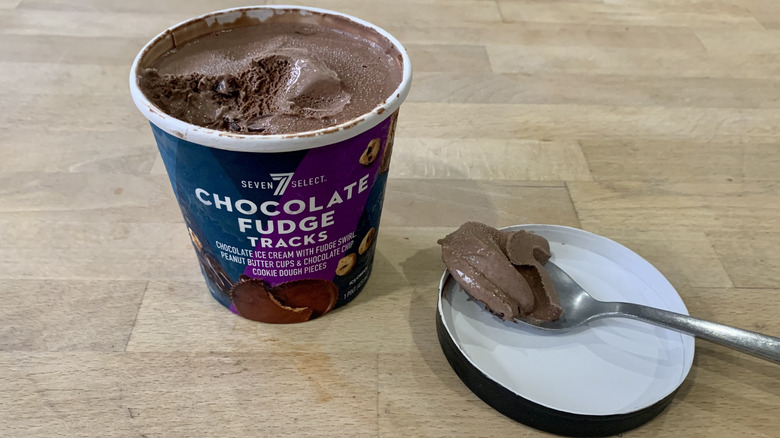 opened Chocolate Fudge Tracks pint with spoonful of ice cream next to it