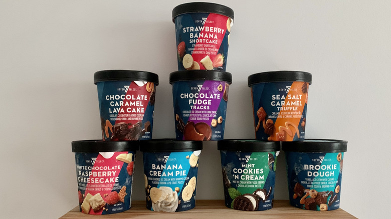eight unopened pints of 7-Select ice cream stacked in pyramid on wooden shelf