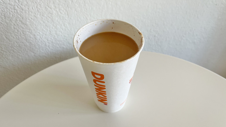 Cup of Dunkin' Pumpkin Latte without lid in a plastic cup
